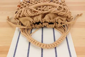 Chic crochet woven handbag with bead embellishments and drawstring inner pouch detail.