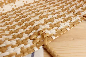 Close-up view of woven plastic bag detail, featuring white and brown interlaced texture.