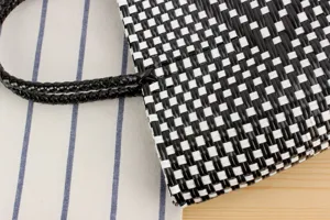 Primo piano dettagliato di una borsa in plastica intrecciata nera e bianca per il tempo libero.