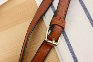 Detailansicht des braunen PU-Leder-Taschenriemens mit goldener Metallschnalle und sauberer Naht.