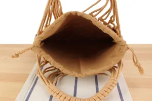 Close-up detail of the woven hollow handbag interior and braided handle construction.