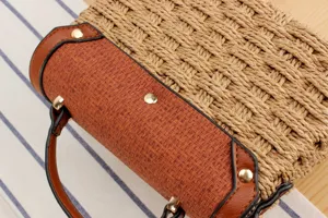 Nahaufnahme Detail der geflochtenen Strohhandtasche mit brauner PU Lederklappe und Nieten.