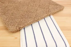 Primer plano detallado de la textura del bolso de paja tejido con tela a rayas.