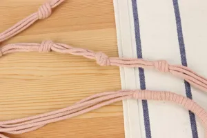 Handcrafted pink woven bag strap detailed close-up, perfect DIY accessory for casual handbags.