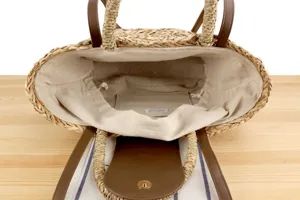 Vista dettagliata della borsa di paglia intrecciata a mano, erba naturale e pelle PU per le vacanze.