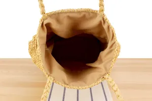 Detailed top view of handmade straw shoulder bag interior, casual beach vacation chic tote.