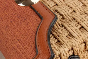 Nahaufnahme der gewebten Damen Umhängetasche aus Stroh mit braunem Lederrand Detail.