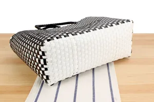 Primo piano dettagliato della texture della borsa intrecciata in plastica nera e bianca.