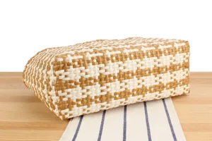 Detail shot of the brown and white woven plastic beach tote bag texture and design.