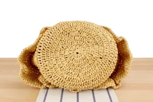 Handmade woven straw bag bottom detail showing fine craftsmanship, perfect for summer beach.