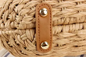 Nahaufnahme Detail der Damen Strohgewebe Handtasche mit brauner Lederlasche und Goldnieten.