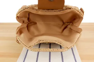 Detailansicht des handgefertigten Strohtaschen-Innenraums mit Futter und Verschluss.