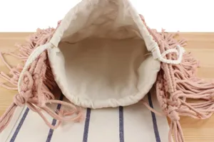 Detailed top view of handmade pink woven macrame drawstring bag interior and texture.