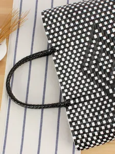 Borsa a mano in plastica intrecciata nera e bianca, elegante borsa a rombi per spiaggia e mare.