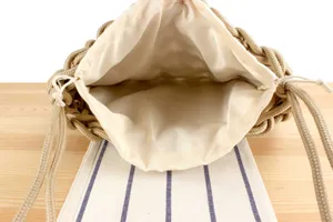 Handwoven rope bucket bag detail view, showing internal lining and drawstring closure.