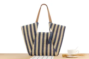 Blue and white striped straw woven tote bag with brown leather handles, casual beach style.