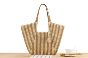 Woven straw tote bag with brown handles and tassel detail, perfect for beach vacation and daily use.