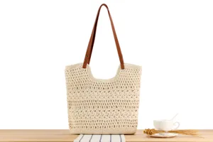 Close-up view of the chic handmade crochet shoulder bag featuring brown leather straps.