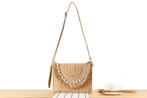 Straw woven crossbody bag for women, seaside vacation clutch with shell fringe, casual style.