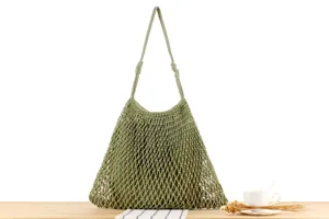 Handgemaakte katoenen touw mesh schoudertas detail toont unieke holle gebreide groene textuur.