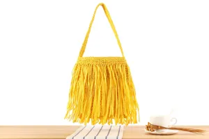 Détail de sac à main jaune en crochet à franges, sac d'épaule stylé pour vacances d'été.
