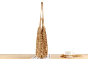 Handgemaakte beige katoenen touw schoudertas, detail van de mesh textuur en het duurzame bandontwerp.