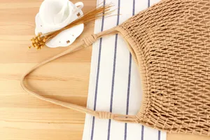 Gedetailleerd overzicht van handgemaakte beige katoenen touw geweven schoudertas.