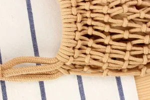 Detailopname van een handgemaakte geweven katoenen touw schoudertas met fijne structuur.