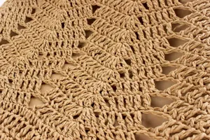 Gros plan sur les details du sac a bandouliere en paille tressee avec beau motif.