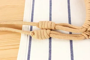 Gedetailleerde opname van handgemaakte katoenen touw schoudertas met prachtig vakmanschap.