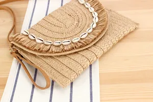 Straw woven crossbody clutch bag with seashell decor, perfect for summer beach and casual daily use.