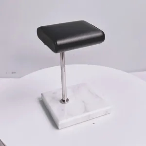 Horlogestandaard met marmeren voet metalen stang en zwart lederen kussen voor winkelvitrine.
