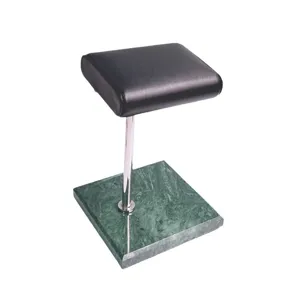 Groene marmeren horlogestandaard met metalen stang en zwart lederen kussen voor display.