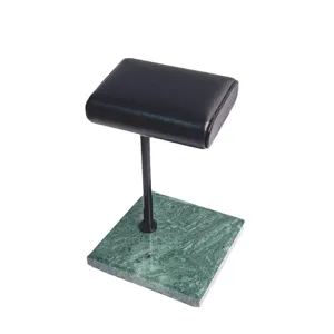 Groene marmeren basis horloge display stand detail met zwarte lederen kussen en metalen stang.