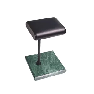 Groene marmeren horlogestandaard met zwart lederen kussen en metalen staaf voor winkelinrichting.