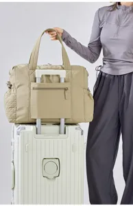 Vista detallada de la gran bolsa de viaje beige con funda para carrito y bolsillos.