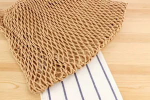 Gedetailleerd overzicht van handgeweven katoenen mesh schoudertas met stijlvolle gestreepte voering.