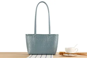 Detail shot of a blue-grey plastic woven tote bag, casual market basket for beach vacation.