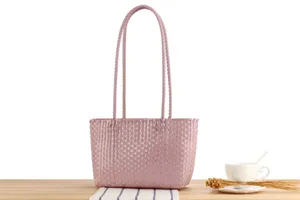 Detailed view of the pink woven plastic tote bag, minimalist style for daily casual use.