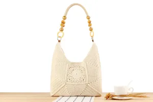 Vista dettagliata della borsa a tracolla beige in crochet lavorata a mano con perle.