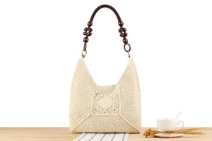 Dettaglio borsa a spalla in crochet beige, manico in perline di legno unico per uso quotidiano.