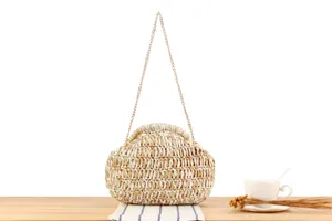 Detail view of a two-tone handmade woven shoulder bag on a wooden table, perfect for beach.
