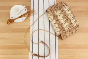 Details of Woven Straw Crossbody Bag with Chain Strap and Leather Accent for Casual Style.