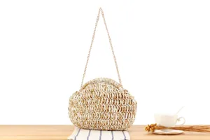 Detailed view of the stylish two-tone woven straw bag with metallic chain strap for casual use.