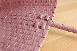Detailed shot of the pink plastic woven basket, showing the fine texture and handle.