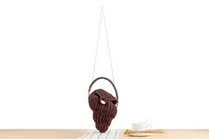 Handmade brown crochet shell bag detail, unique woven texture with elegant pearl chain strap.