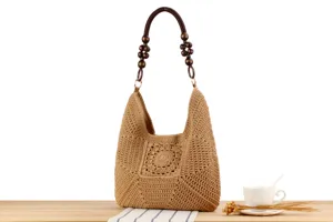 Dettaglio della borsa a spalla in paglia intrecciata con crochet e manico di perle in legno.