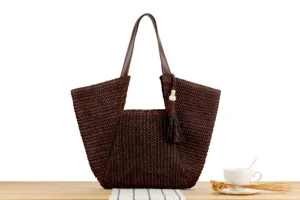 Detailed view of the stylish dark brown woven tote bag with tassel pendant for beach and daily.