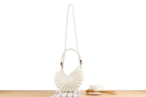 Handmade crochet shell handbag detail, chic pearl strap design for daily casual beach vacation.