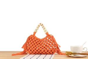 Orange woven macrame handbag with wooden bead handle and stylish fringe detail for use.